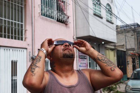 Foto de Octubre 14, 2023 en Nezahualcyotl, México: Una persona observa el eclipse solar anular, se observa parcialmente cuando la Luna cubre hasta el 70% del disco solar - Imagen libre de derechos