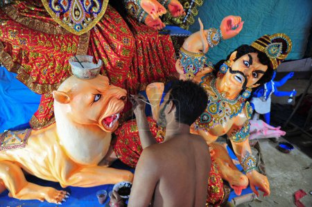 Téléchargez les photos : 16 octobre 2023 Sylhet, Bangladesh : SAGOR PAUL, artiste idolâtre prometteur, colore la sculpture d'une divinité hindoue en préparation du prochain Festival Durga Puja 2023 à Sylhet, Bangladesh - en image libre de droit