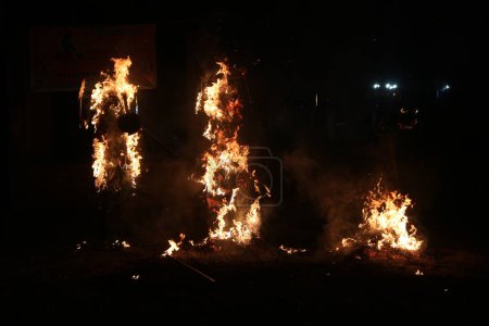 Téléchargez les photos : 24 octobre 2023, Srinagar, Inde : Les Pandits du Cachemire utilisent des étincelles pour créer des formes alors qu'ils brûlent les effigies du roi démon Ravana pendant le festival de Dushera - en image libre de droit