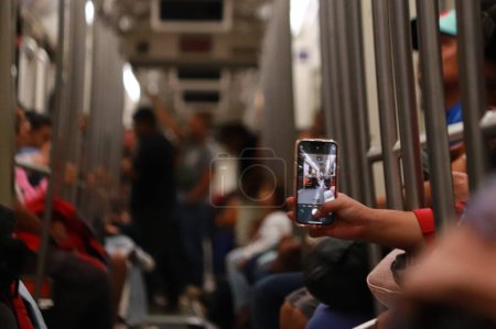 Photo for October 29, 2023 in Mexico City, Mexico:  A Passenger take a photo while  travels in the subway during the reopening of Metro Line 1 to the public after the Pantitln - Isabel la Catlica Section has been repaired - Royalty Free Image