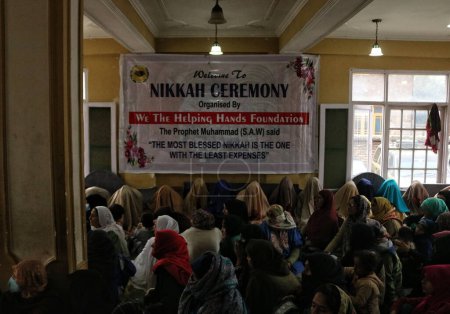 Foto de Noviembre 01,2023, Srinagar Cachemira, India: Las novias con velos se sientan en el suelo mientras esperan asistir a una ceremonia de matrimonio en masa, en Srinagar - Imagen libre de derechos