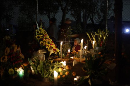 Téléchargez les photos : 2 novembre 2023, Mexico, Mexique : Des familles décorent les tombes de leurs proches, enfants et veillent également sur les tombes des adultes dans le cadre de la Journée des Morts au Panthéon de San Gregorio Atlapulco dans le bureau du maire de Xochimilco - en image libre de droit
