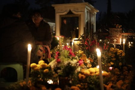 Téléchargez les photos : 2 novembre 2023, Mexico, Mexique : Des familles décorent les tombes de leurs proches, enfants et veillent également sur les tombes des adultes dans le cadre de la Journée des Morts au Panthéon de San Gregorio Atlapulco dans le bureau du maire de Xochimilco - en image libre de droit