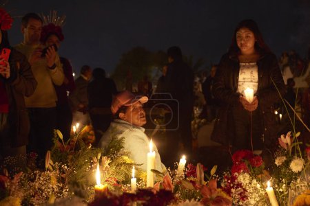Téléchargez les photos : 2 novembre 2023, Mexico, Mexique : Des parents décorent les tombes avec des fleurs de cempasuchil et illuminent les tombes de leurs proches avec des bougies, remplissant le panthéon de couleur et de folklore, lors des célébrations de la Journée des Morts - en image libre de droit