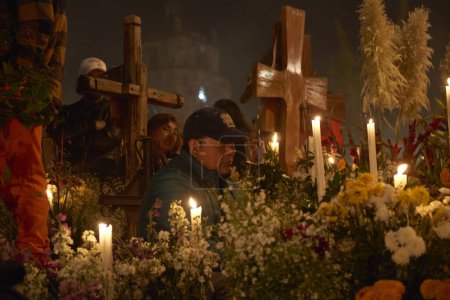 Foto de 2 de noviembre de 2023, Ciudad de México, México: Los familiares decoran las tumbas con flores de cempasuchil e iluminan las tumbas de sus seres queridos con velas, llenando el panteón de color y folclore, durante las celebraciones del Día de los Muertos - Imagen libre de derechos