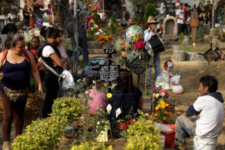 Foto de 2 de noviembre de 2023, Ciudad de México, México: Familiares decoran las tumbas de sus seres queridos con esculturas de barro durante el festival Día de los Muertos en el Panteón de San Antonio Tecomitl en la Alcaldía de Milpa Alta en la Ciudad de México - Imagen libre de derechos