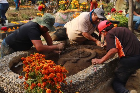 Photo for November 2, 2023 in Mexico City, Mexico: Relatives attend the pantheon of San Antonio Tecmitl and sculpt the earth with elements such as sawdust, lime and flowers, as an offering to receive their dead - Royalty Free Image