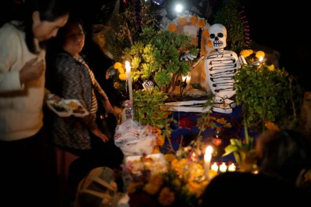 Foto de 2 de noviembre de 2023, Ciudad de México, México: Familiares decoran las tumbas de sus seres queridos con esculturas de barro durante el festival Día de los Muertos en el Panteón de San Antonio Tecomitl en la Alcaldía de Milpa Alta en la Ciudad de México - Imagen libre de derechos