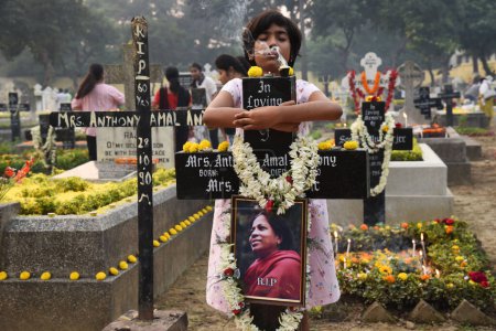 Téléchargez les photos : 2 novembre 2023, Kolkata, Inde : Les dévots chrétiens assistent aux panthéons pour offrir des prières à côté des tombes de leurs amours l'un dans un lors de la "Journée de toutes les âmes" à Kolkata - en image libre de droit