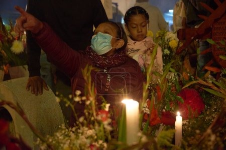 Téléchargez les photos : 2 novembre 2023, Mexico, Mexique : Des parents décorent les tombes avec des fleurs de cempasuchil et illuminent les tombes de leurs proches avec des bougies, remplissant le panthéon de couleur et de folklore - en image libre de droit