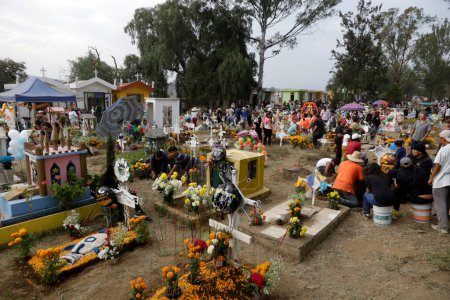 Téléchargez les photos : 2 novembre 2023, Mexico, Mexique : Des parents décorent les tombes de leurs proches avec des sculptures de boue lors de la fête de la Journée des Morts au Panthéon de San Antonio Tecomitl dans le bureau du maire de Milpa Alta à Mexico - en image libre de droit
