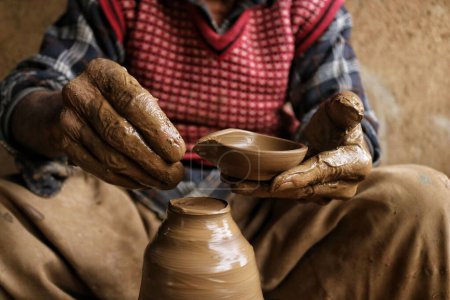 Photo for November 02,2023, Srinagar Kashmir, India : Abdul Salam Kumar, a Kashmiri Muslim potter makes earthen lamps at his home workshop ahead of the Diwali festival, on the outskirts of Srinagar - Royalty Free Image