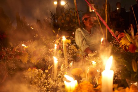 Foto de 2 de noviembre de 2023, Ciudad de México, México: Los familiares decoran las tumbas con flores de cempasuchil e iluminan las tumbas de sus seres queridos con velas, llenando el panteón de color y folclore, durante las celebraciones del Día de los Muertos - Imagen libre de derechos