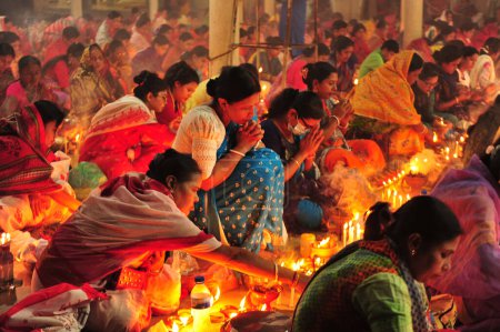 Téléchargez les photos : 04 novembre 2023 Sylhet-Bangladesh : Des dévots hindous s'assoient ensemble sur le sol d'un temple pour observer la fête de Rakher Upobash au temple de Loknath à Sylhet, Bangladesh - en image libre de droit