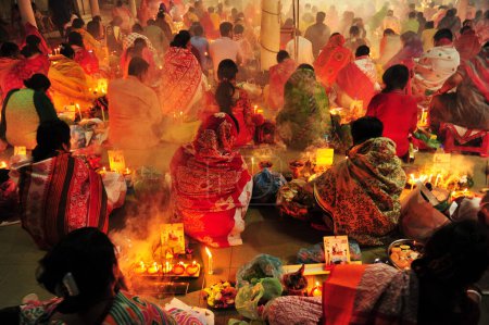 Téléchargez les photos : 04 novembre 2023 Sylhet-Bangladesh : Des dévots hindous s'assoient ensemble sur le sol d'un temple pour observer la fête de Rakher Upobash au temple de Loknath à Sylhet, Bangladesh - en image libre de droit