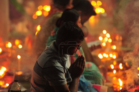 Foto de 04 noviembre 2023 Sylhet-Bangladesh: Los devotos hindúes se sientan juntos en el suelo de un templo para observar el festival Rakher Upobash en el Templo Loknath en Sylhet, Bangladesh - Imagen libre de derechos