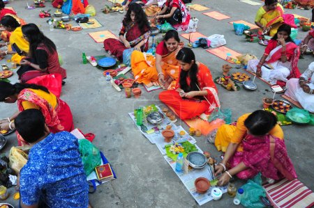 Photo for 07 November 2023 Sylhet-Bangladesh: Hindu devotees sit together taking preparation with lamp, food and other articles of the rituals sit on the floor of a temple to observe the Rakher Upobash festival in Loknath Temple in Sylhet, Bangladesh - Royalty Free Image