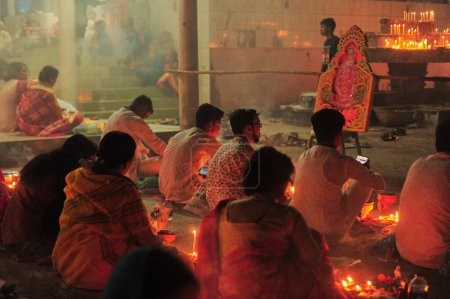 Téléchargez les photos : 07 novembre 2023 Sylhet-Bangladesh : Des dévots hindous s'assoient ensemble sur le sol d'un temple pour observer la fête de Rakher Upobash au temple de Loknath à Sylhet, Bangladesh. Lokenath Brahmachari qui s'appelle Baba Lokenath était un saint hindou du XVIIIe siècle - en image libre de droit