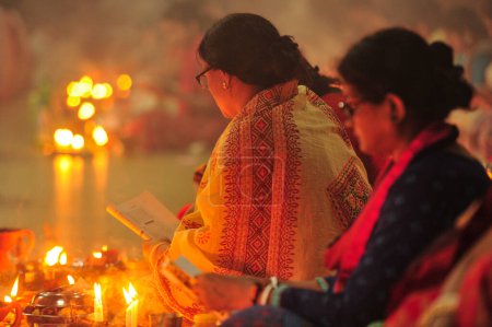 Téléchargez les photos : 07 novembre 2023 Sylhet-Bangladesh : Des dévots hindous s'assoient ensemble sur le sol d'un temple pour observer la fête de Rakher Upobash au temple de Loknath à Sylhet, Bangladesh. Lokenath Brahmachari qui s'appelle Baba Lokenath était un hindou du XVIIIe siècle - en image libre de droit
