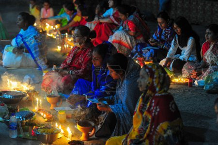 Foto de 07 noviembre 2023 Sylhet-Bangladesh: Los devotos hindúes se sientan juntos en el suelo de un templo para observar el festival Rakher Upobash en el Templo Loknath en Sylhet, Bangladesh. Lokenath Brahmachari que se llama Baba Lokenath era un santo hindú del siglo XVIII. - Imagen libre de derechos