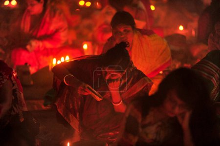 Téléchargez les photos : 07 novembre 2023 Sylhet-Bangladesh : Des dévots hindous s'assoient ensemble sur le sol d'un temple pour observer la fête de Rakher Upobash au temple de Loknath à Sylhet, Bangladesh. Lokenath Brahmachari qui s'appelle Baba Lokenath était un hindou du XVIIIe siècle - en image libre de droit