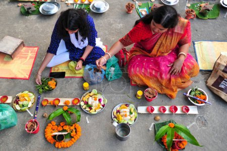 Téléchargez les photos : 07 novembre 2023 Sylhet-Bangladesh : Des dévots hindous s'assoient ensemble pour préparer une lampe, de la nourriture et d'autres articles des rituels s'assoient sur le sol d'un temple pour observer le festival Rakher Upobash au temple Loknath à Sylhet, Bangladesh - en image libre de droit