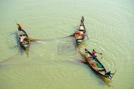 Téléchargez les photos : 08 novembre 2023 Sylhet-Bangladesh : Des pêcheurs pêchent avec un filet sur un bateau à la rivière Surma dans le Guainghat Upazila de Sylhet - en image libre de droit