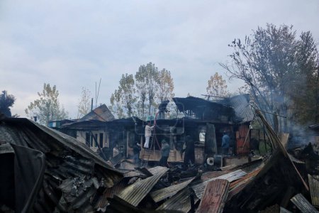 Téléchargez les photos : 11 novembre 2023, Srinagar Cachemire, Inde : Des Cachemiris travaillent à éteindre un incendie qui a détruit plusieurs péniches au lac Dal à Srinagar - en image libre de droit