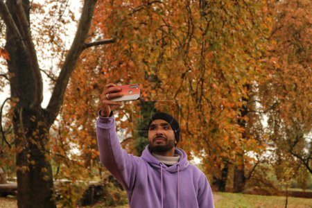 Téléchargez les photos : 10 novembre 2023, Srinagar Cachemire, Inde : Un visiteur prend des photos selfie au jardin moghol recouvert de feuilles tombées de puissants arbres chinois à Nishat à Srinagar - en image libre de droit
