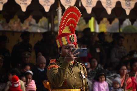 Foto de Noviembre 09,2023, Srinagar Cachemira, India: Una mujer soldado de la Fuerza de Seguridad Fronteriza India (BSF) toma fotos durante un desfile de desmayos en Humhama, en las afueras de Srinagar - Imagen libre de derechos