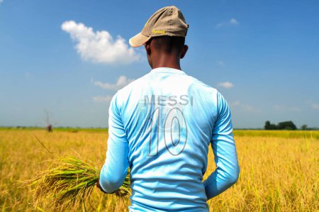 Foto de 08 noviembre 2023 Sylhet-Bangladesh Un joven granjero que es un gran fan de Messi del equipo de fútbol argentino que todavía lleva la camiseta de Lionel Messi de Argentina - Imagen libre de derechos