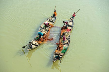 Téléchargez les photos : 08 novembre 2023 Sylhet-Bangladesh : Des pêcheurs pêchent avec un filet sur un bateau à la rivière Surma dans le Guainghat Upazila de Sylhet - en image libre de droit