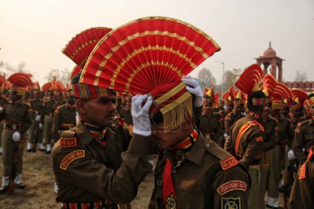 Foto de Noviembre 09,2023, Srinagar Cachemira, India: Un nuevo recluta de la Fuerza de Seguridad Fronteriza India (BSF) ajusta el turbante de su colega durante un desfile de desmayos en Humhama, en las afueras de Srinagar - Imagen libre de derechos