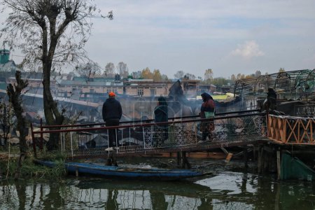Foto de 11 de noviembre de 2023, Srinagar Cachemira, India: La gente mira las casas flotantes destripadas que fueron destruidas en un incidente de incendio en el lago Dal en Srinagar. Un incendio masivo estalló en las casas flotantes en el centro turístico del lago Dal en Srinagar - Imagen libre de derechos