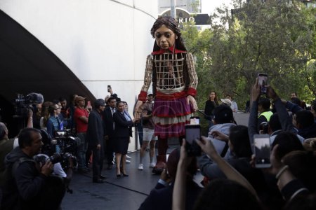 Foto de 16 de noviembre de 2023, Ciudad de México, México: La presidenta del Senado, Ana Lilia Rivera, da la bienvenida a la pequeña Amal, una marioneta gigante de una niña siria de 10 años, símbolo de los derechos de los refugiados en todo el mundo - Imagen libre de derechos