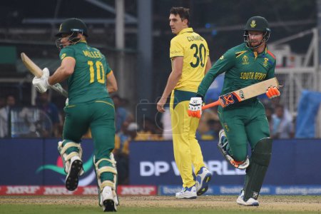 Photo for Kolkata,India ,October 16:South Africa's David Miller, Left and  Rassie van der Dussen take runs and Australia's captain Pat Cummins look during the ICC Men's Cricket World Cup second semifinal match between Australia and South Africa in Kolkata - Royalty Free Image