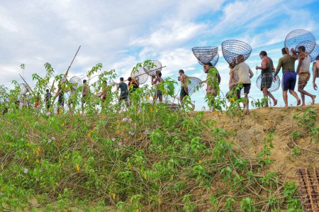Foto de 28 noviembre 2023 Sylhet-Bangladesh: La gente rural armada con trampas de bambú y red participa en la celebración en un festival de pesca de invierno de 200 años en el beel jofra de la unión de gasbari de Kanaighat upazila de Sylhet, Bangladesh - Imagen libre de derechos