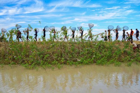 Foto de 28 noviembre 2023 Sylhet-Bangladesh: La gente rural armada con trampas de bambú y red participa en la celebración en un festival de pesca de invierno de 200 años en el beel jofra de la unión de gasbari de Kanaighat upazila de Sylhet - Imagen libre de derechos