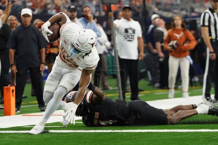 Photo for December 2, 2023, Arlington, Texas, United States: Texas Longhorns running back Jaydon Blue breaks the tackle of Oklahoma State Cowboys linebacker Nickolas Martin  during the 2023 Dr Pepper Big 12 Championship game between Texas Longhorns - Royalty Free Image