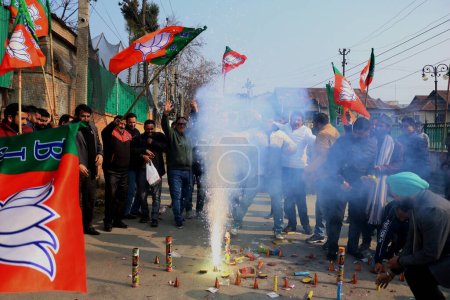 Foto de Diciembre 04,2023, Srinagar Cachemira, India: Líderes y simpatizantes del Partido Bharatiya Janata (BJP) encienden petardos para celebrar la victoria del partido en las elecciones de la Asamblea de Madhya Pradesh, Chhattisgarh y Rajasthan, en Srinagar - Imagen libre de derechos