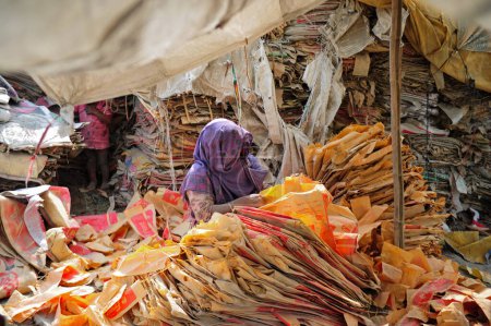 Téléchargez les photos : 10 décembre 2023 Sylhet-Bangladesh : Des travailleuses risquent leur vie pour laver des sacs de ciment près de la rivière Surma à Sylhet, au Bangladesh. De plus, comme cela nuit à leur santé à long terme, la poussière de plastique remplit également le lit de la rivière - en image libre de droit