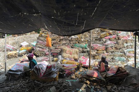 Foto de 10 de diciembre de 2023 Sylhet-Bangladesh: Mujeres trabajadoras están arriesgando sus vidas para lavar bolsas de cemento junto al río Surma en Sylhet, Bangladesh. Además, como está dañando su salud a largo plazo, el polvo de plástico también está llenando el lecho del río. - Imagen libre de derechos