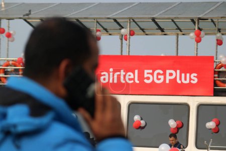 Téléchargez les photos : 12 décembre 2023, Srinagar Cachemire, Inde : Un homme parle sur son téléphone portable logo passé de Airtel 5G Plus est vu lors de la 5G en direct plus l'expérience à Srinagar. Airtel a annoncé le lancement de ses services 5G de pointe - en image libre de droit