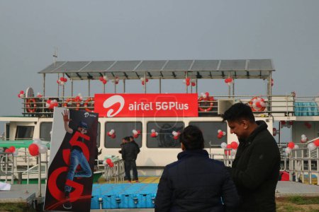 Téléchargez les photos : Décembre 12,2023, Srinagar Cachemire, Inde : Les gens se tiennent derrière le logo d'Airtel 5G Plus est vu lors de la 5G en direct plus l'expérience à Srinagar. Airtel a annoncé le lancement de ses services 5G de pointe - en image libre de droit
