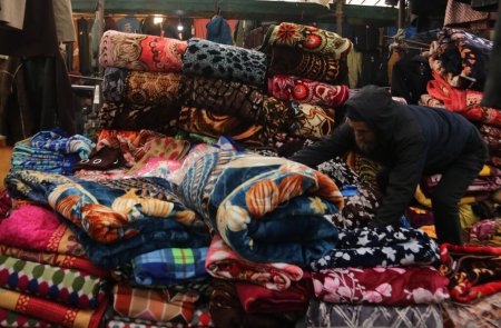 Foto de Diciembre 13,2023, Srinagar Cachemira, India: La gente compra gorras de invierno y otros artículos en un mercado en Srinagar. Con la llegada del invierno, los cachemires ordinarios comienzan a prepararse para el clima duro, comprando suéteres, chaquetas y otras prendas de abrigo. - Imagen libre de derechos