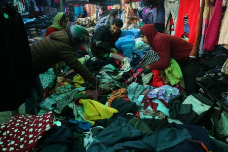 Foto de Diciembre 13,2023, Srinagar Cachemira, India: La gente compra gorras de invierno y otros artículos en un mercado en Srinagar. Con la llegada del invierno, los cachemires ordinarios comienzan a prepararse para el clima duro, comprando suéteres. - Imagen libre de derechos