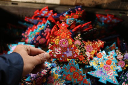 Foto de 16 de diciembre de 2023, Srinagar Cachemira, India: Adornos de Navidad están listos en el interior del taller antes de enviarlos al mercado antes de las celebraciones de Navidad en Srinagar. Los artesanos dicen que los artículos de Navidad están hechos de papier-mache y son - Imagen libre de derechos