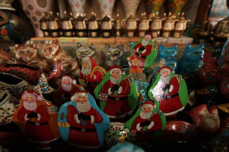 Téléchargez les photos : 16 décembre 2023, Srinagar Cachemire, Inde : Les ornements de Noël, y compris le Père Noël, sont prêts à l'atelier avant de les envoyer au marché avant les célébrations de Noël à Srinagar. Les artisans disent que les articles de Noël sont faits de papie - en image libre de droit