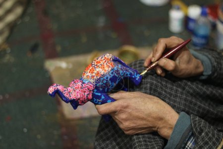 Téléchargez les photos : 16 décembre 2023, Srinagar Cachemire, Inde : Un artisan du Cachemire termine un ornement de Noël dans son atelier avant les célébrations de Noël à Srinagar - en image libre de droit