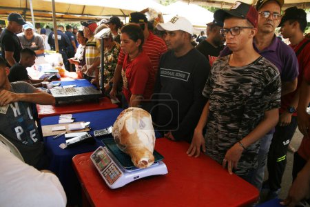 Foto de 18 de diciembre de 2023, San Francisco, Venezuela: Los venezolanos se alinean para comprar alimentos este lunes durante el programa de caridad Popular Markets con el objetivo de beneficiar a miles de familias con la venta de 300 toneladas de alimentos de la canasta básica - Imagen libre de derechos